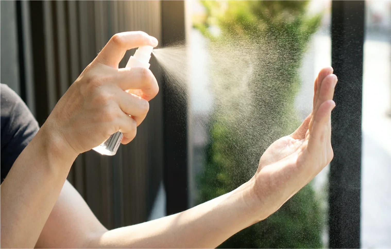 Someone spraying hand sanitizer on their hands to prevent contamination and spread of bacteria