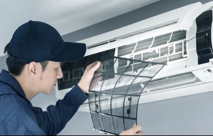 An aircon technician checking the aircon filters and doing regular maintenance