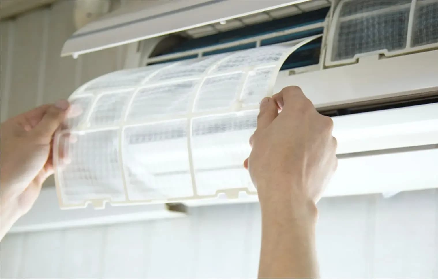 A homeowner checking if their aircon filters are clean and set properly 
