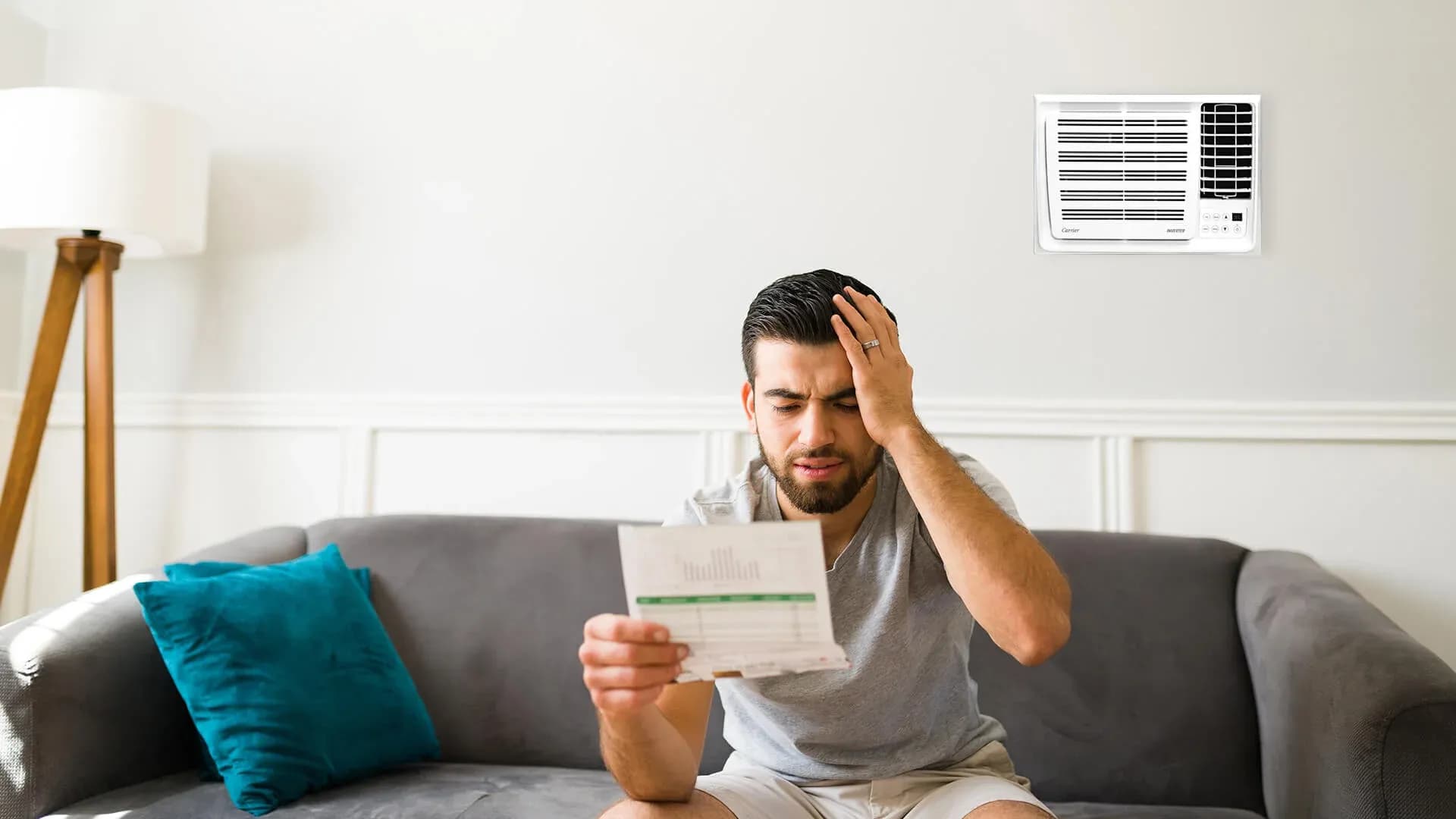 A stressed homeowner looking at their electricity bill and worrying about the aircon consumption per hour